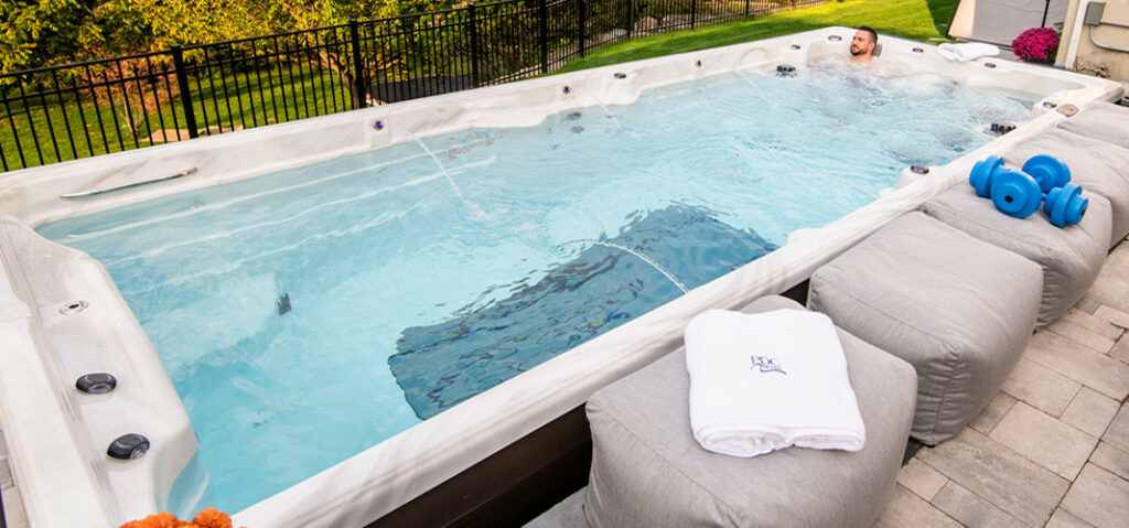 man relaxing in a backyard swim spa