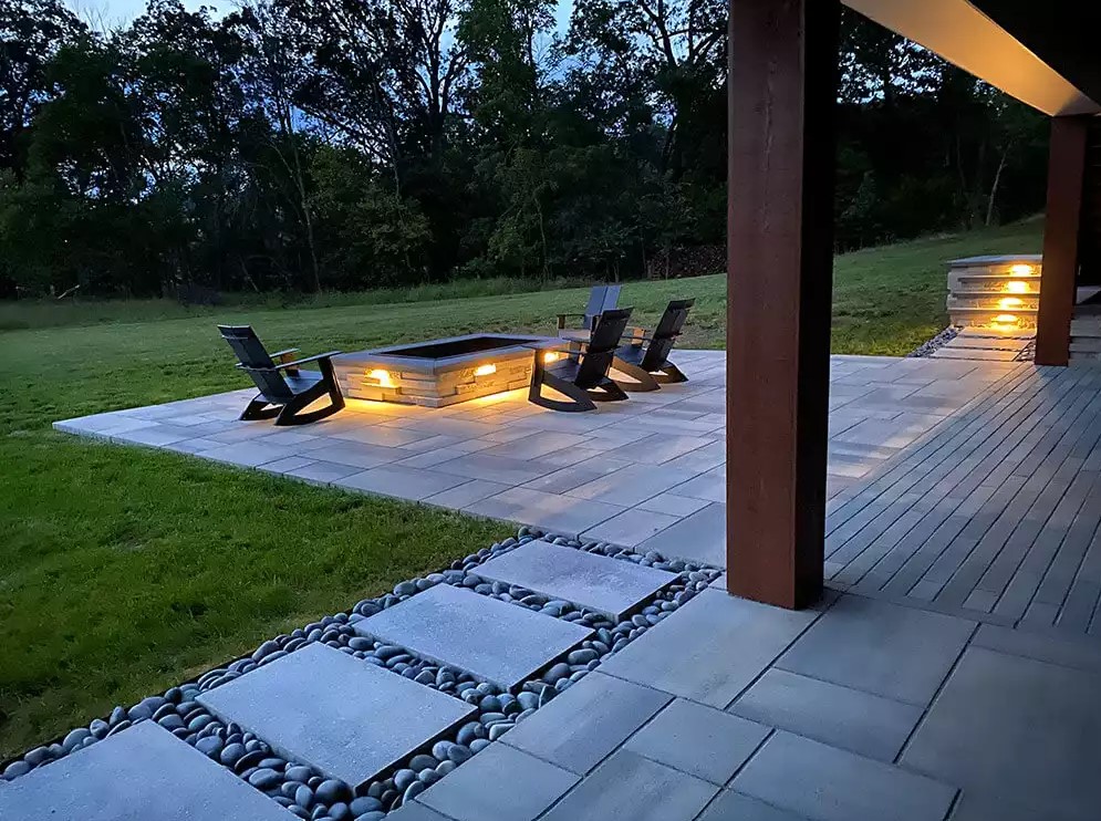 landscape installation with stone fireplace and outdoor lighting